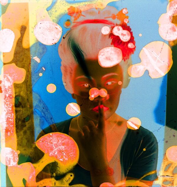 A woman with pink hair is looking through the window.