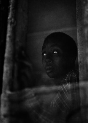 A young boy looking out of the window.