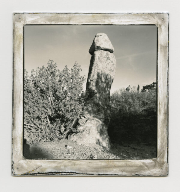 A stone pillar in the middle of a field.