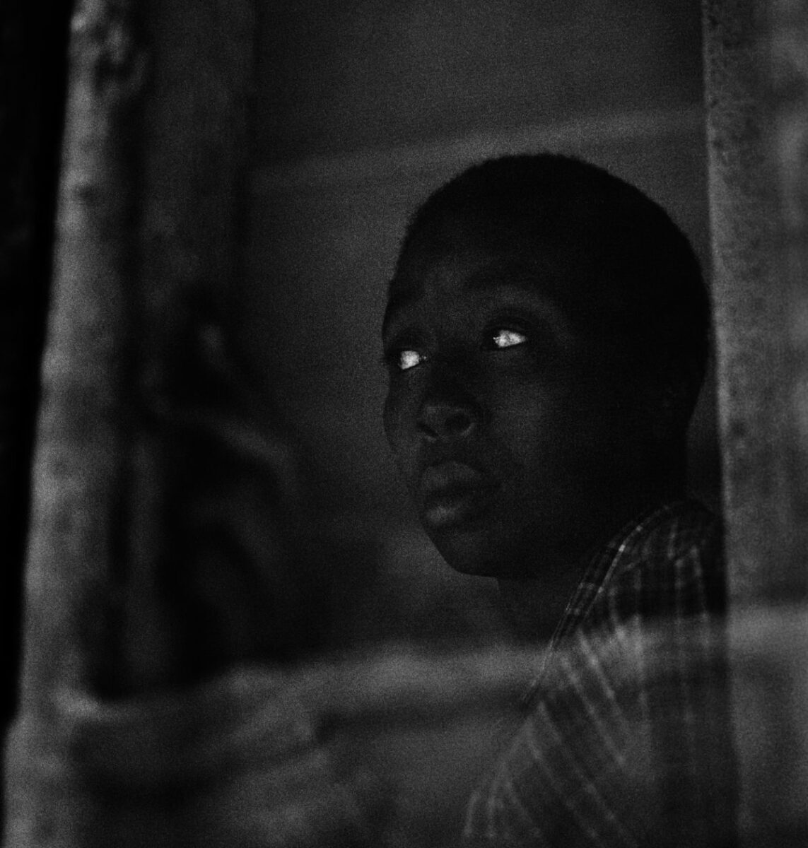 Person gazing thoughtfully from a window.