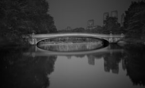 A bridge over water with trees in the background.