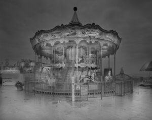 A carousel is shown in the middle of a foggy night.