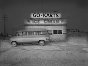 A van parked in front of an ice cream shop.