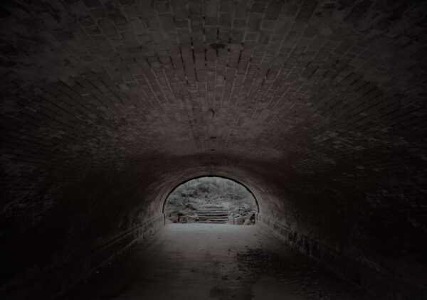A dark tunnel with a light at the end of it.