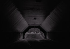 A dark tunnel with a view of the ground.