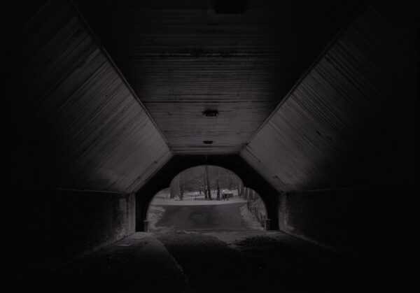 A dark tunnel with a view of the ground.