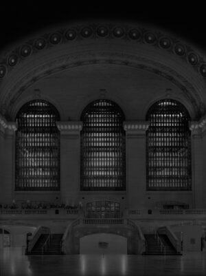 A black and white photo of three windows in an old building.