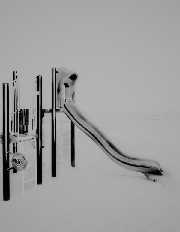 A black and white photo of a slide in the snow.