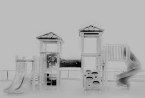 A black and white photo of two playgrounds.