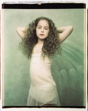 A young woman with long hair and a white dress.
