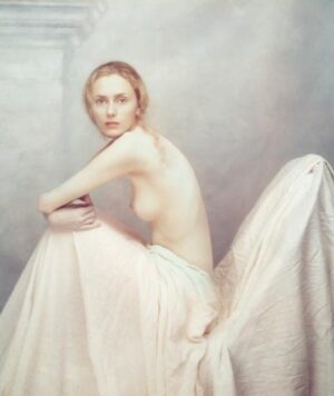 A woman in white dress sitting on the ground.