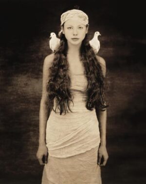 A woman with long hair and two birds on her head.