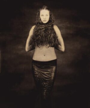 A woman in black leather skirt and fur collar.