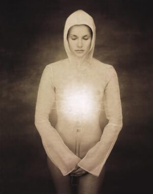 A woman in white hoodie holding hands with light.