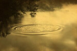 A lake with fog and water in the middle of it.