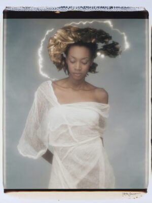A woman in white dress with hair blowing in the wind.
