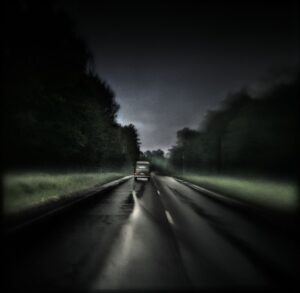 A blurry image of the road with trees in the background.