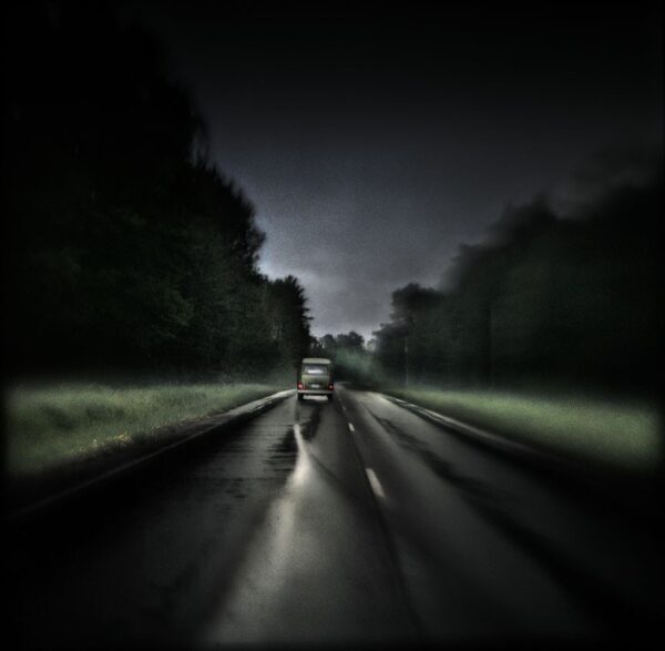 A blurry image of the road with trees in the background.