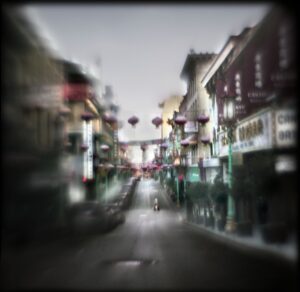 A blurry image of an empty street with buildings.