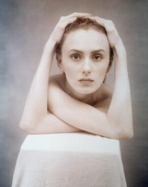 A woman with her arms crossed over her head.