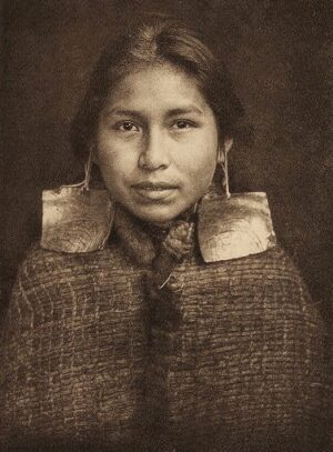 A woman with long hair and big earrings.