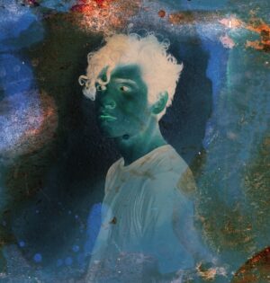 A person with white hair and blue background