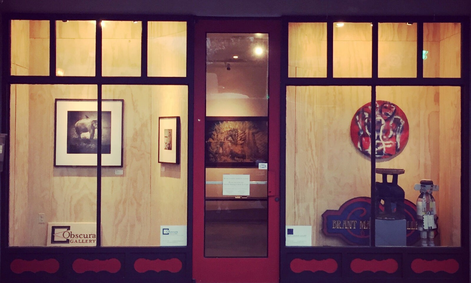 Gallery window displaying artwork and sculptures.