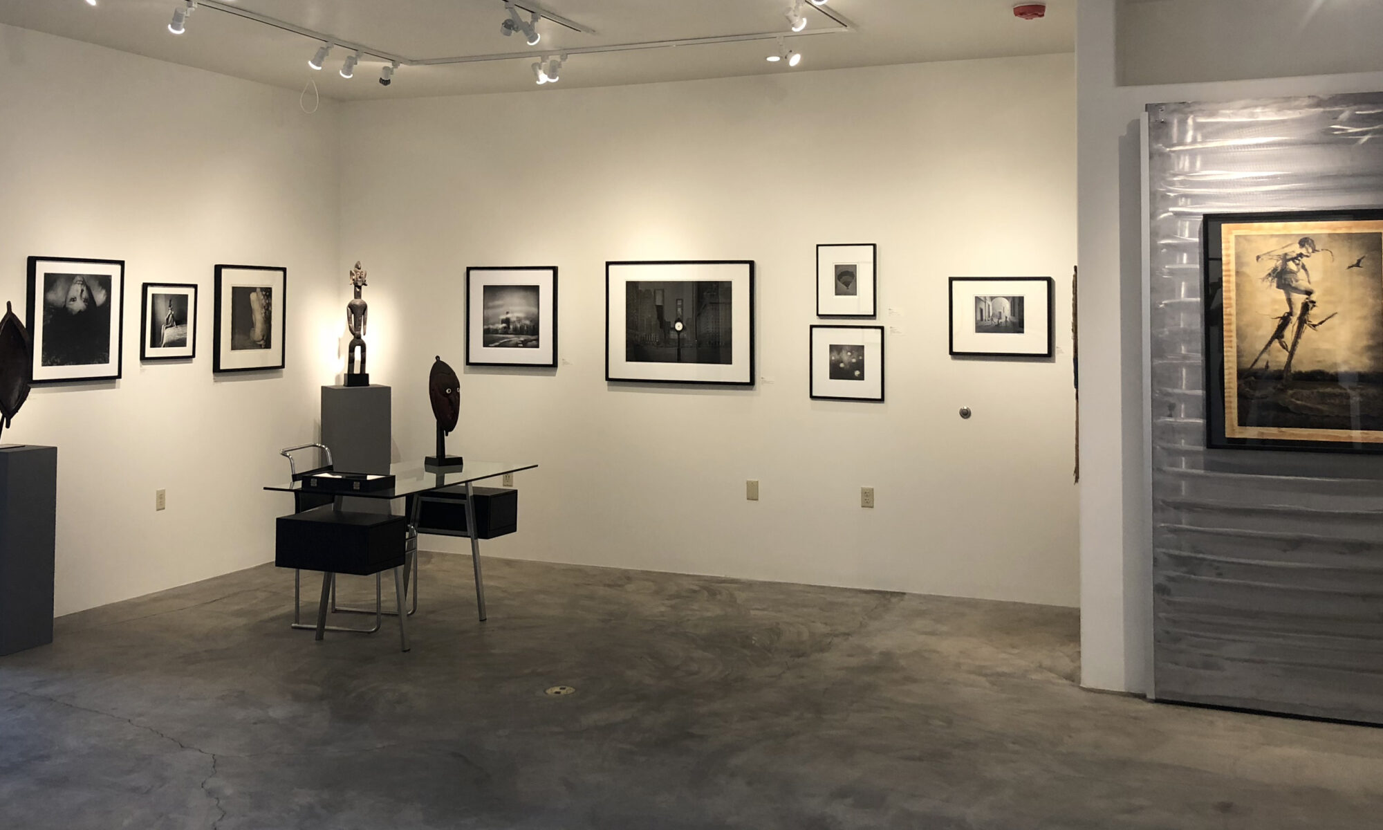 Art gallery featuring framed photographs and sculptures.