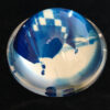 A glass sphere with blue and white designs on it.