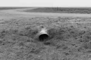 A pipe in the middle of an empty field.
