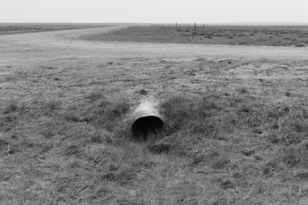 A pipe in the middle of an empty field.