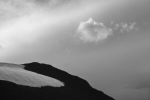 A black and white photo of the sky above a mountain.