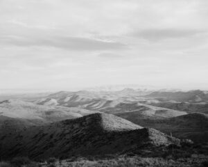 A black and white photo of mountains in the distance.