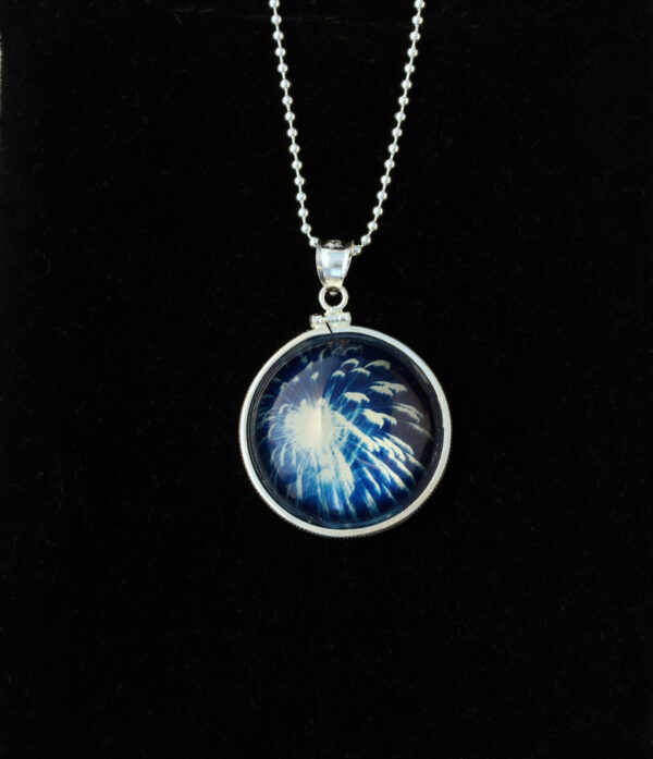 A necklace with a picture of a blue fire.