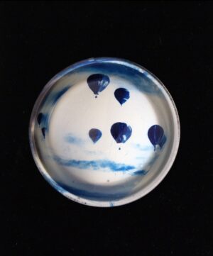 A bowl with blue and white balloons on it.