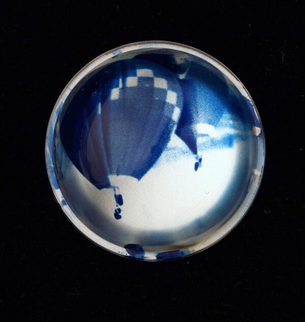 A glass ball with a picture of a balloon in it.