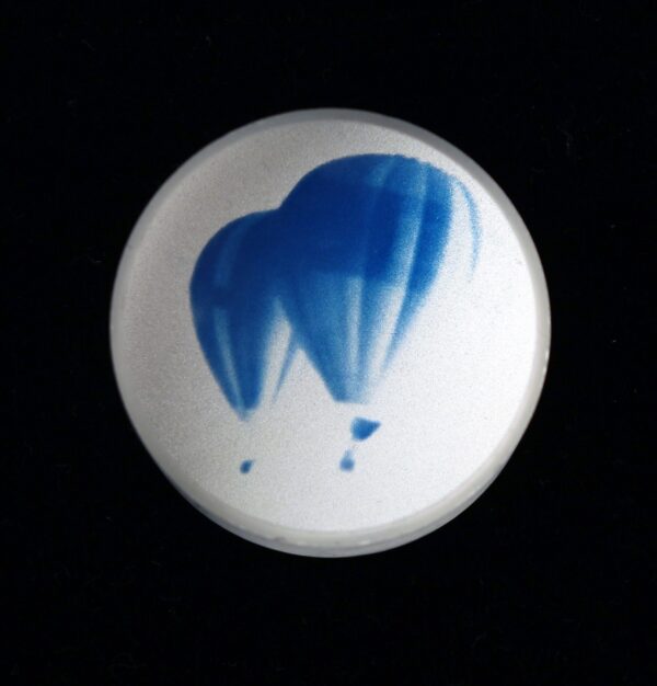 A blue balloon is seen in the dark.