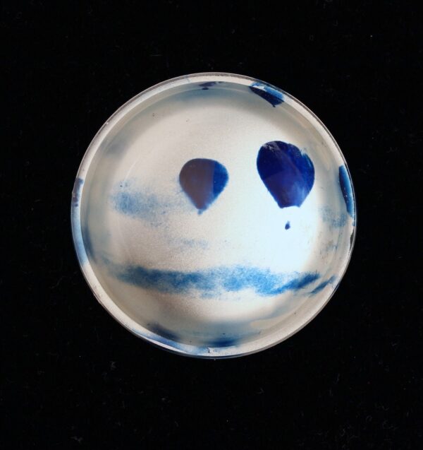 A blue and white bowl with a face on it.
