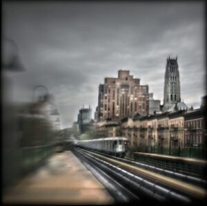 A train traveling down tracks near tall buildings.