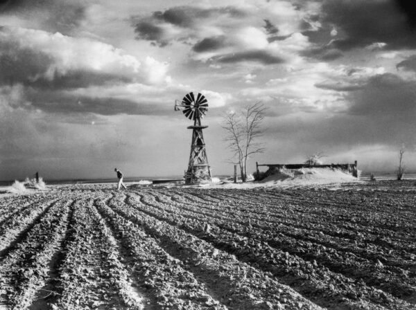 A black and white photo of an old windmill.