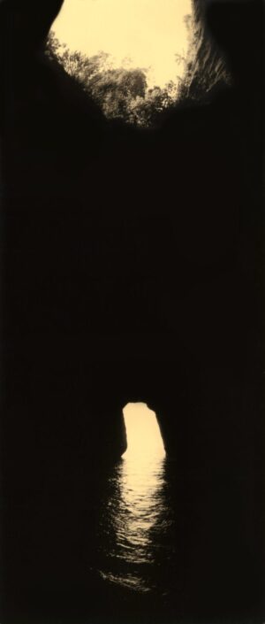 A lit candle in the dark with black background