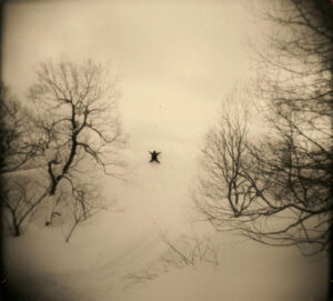 A person is flying through the air while riding skis.