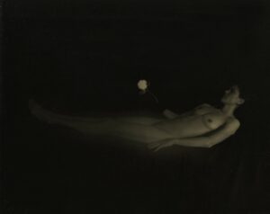 A naked woman floating in the air with her arms outstretched.