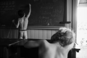 A boy and girl are writing on the chalkboard.