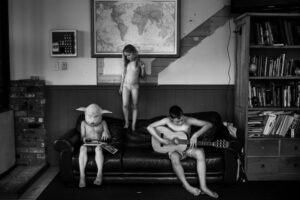 A boy and two other people sitting on the couch