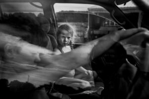 A young girl sitting in the back of a car.