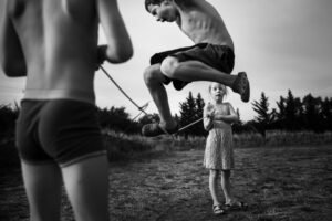 A man jumping in the air with two people watching.