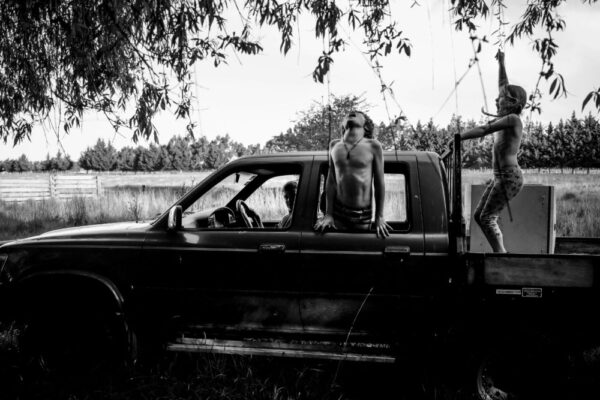 A man sitting in the back of an old truck.