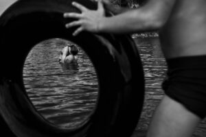 A person is swimming in the water with an object.