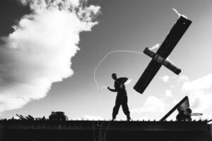 A man standing on top of a building holding something.